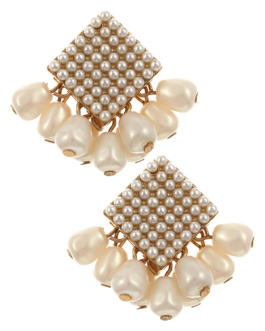 Pair of pearl earrings with gold square accents on a white background