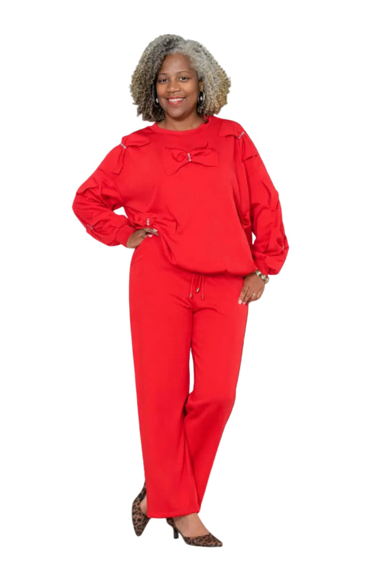 Woman wearing a red outfit with a bow detail on a white background