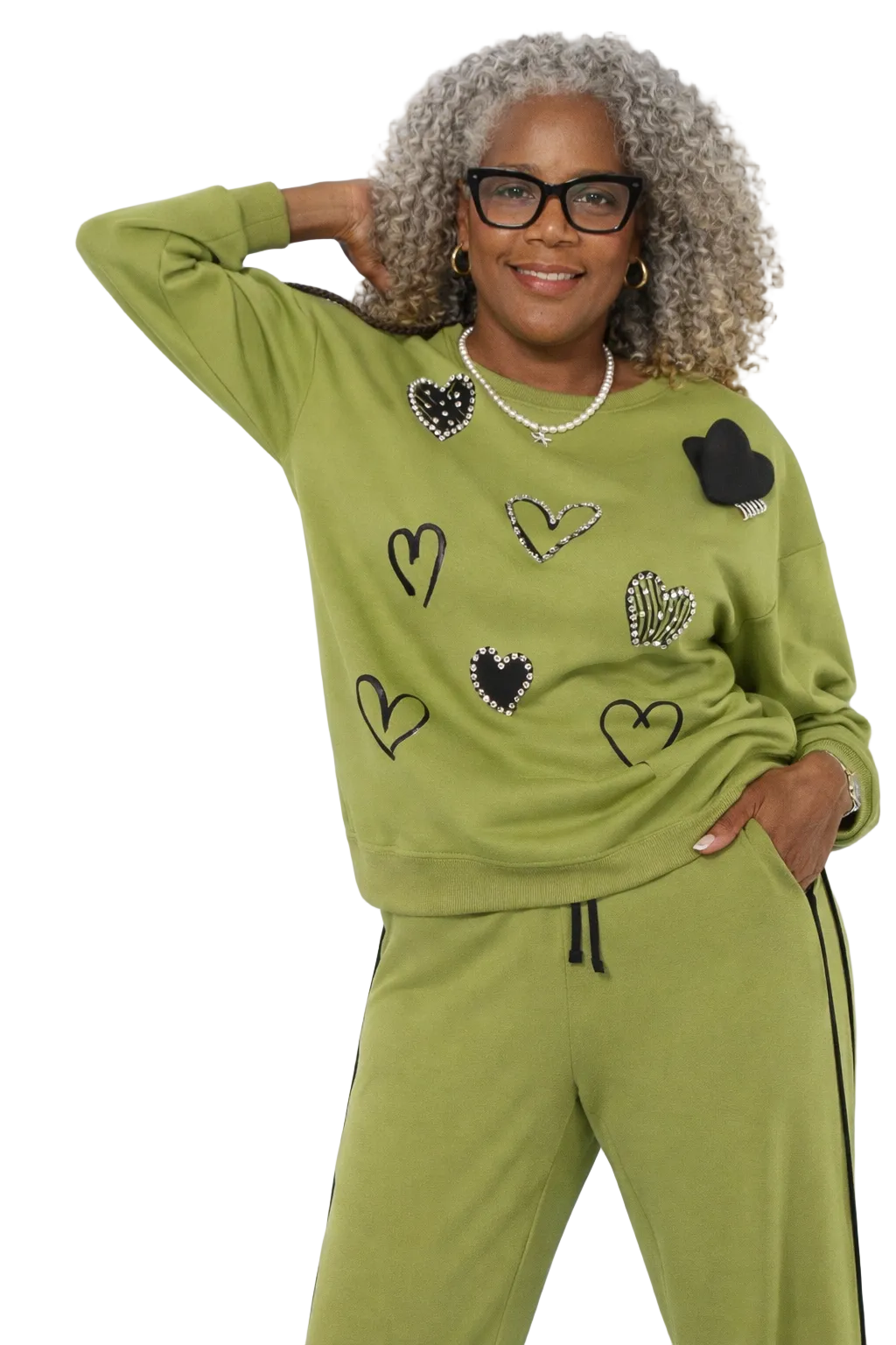Woman wearing a green tracksuit with heart designs on a white background