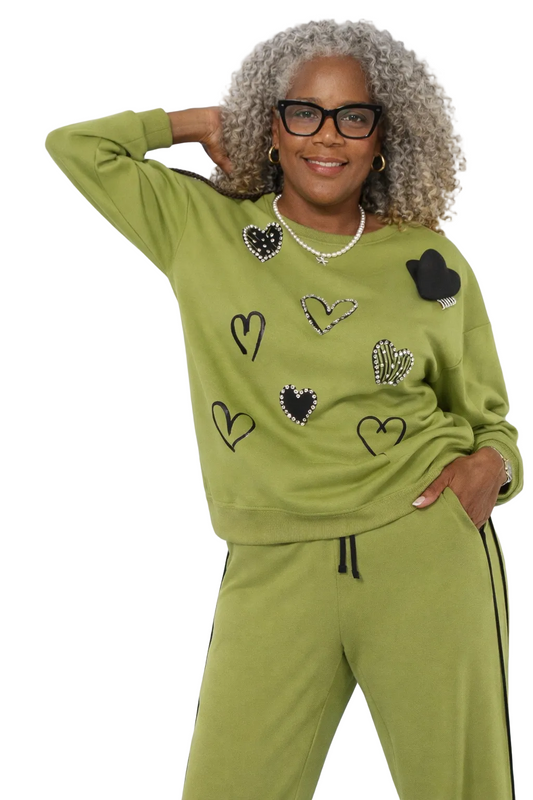 Woman wearing a green tracksuit with heart designs on a white background