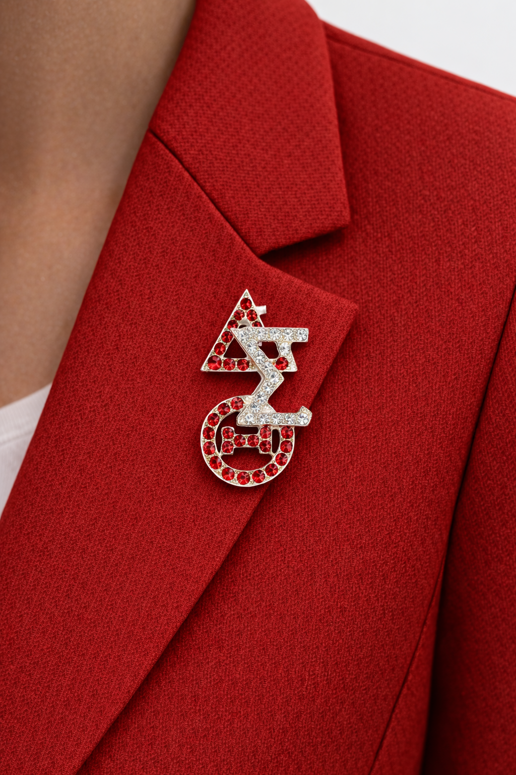 Red blazer with a decorative brooch featuring symbols.