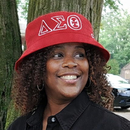 Person wearing a red Delta Sigma Theta Bucket Hat standing outdoors.