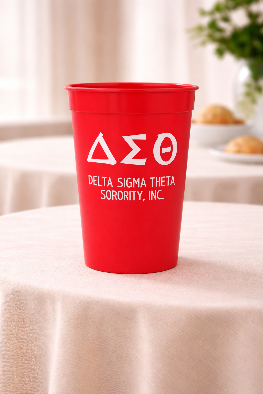 Red cup with Delta Sigma Theta Sorority, Inc. logo on a tablecloth-covered table.