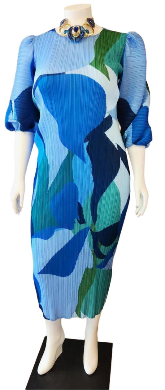 Mannequin wearing a blue and green patterned dress on a black stand.