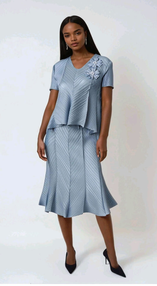 Woman wearing a light blue dress with a floral embellishment on a white background