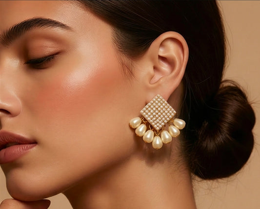 Close-up of a woman wearing a pearl earring with a neutral background